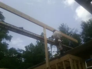 Carpenter setting a ridge beam over a new addition frame — Ice Dam Removal by Roofing Brothers in Elliottsburg
