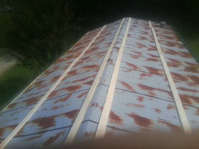 Rusted metal roof panels with new wood purlins before replacement — Storm Damage Roof Repair in Elliottsburg by Roofing Brothers