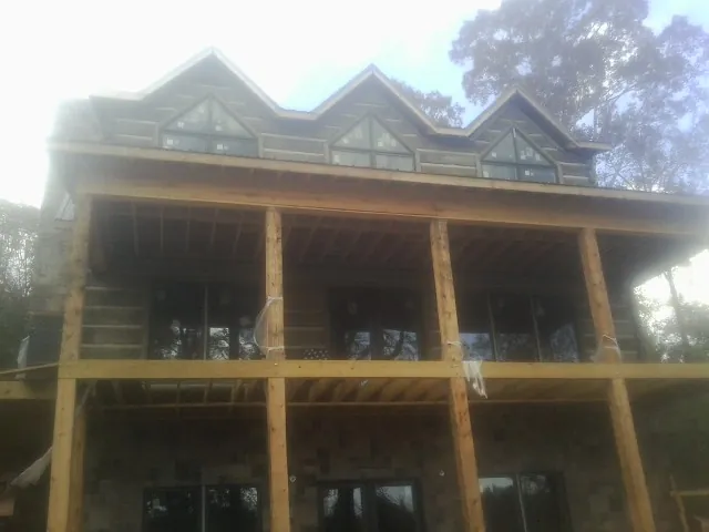 Dormers and porch framing on a large log home under construction — Roof Coating work by our crew in Elliottsburg